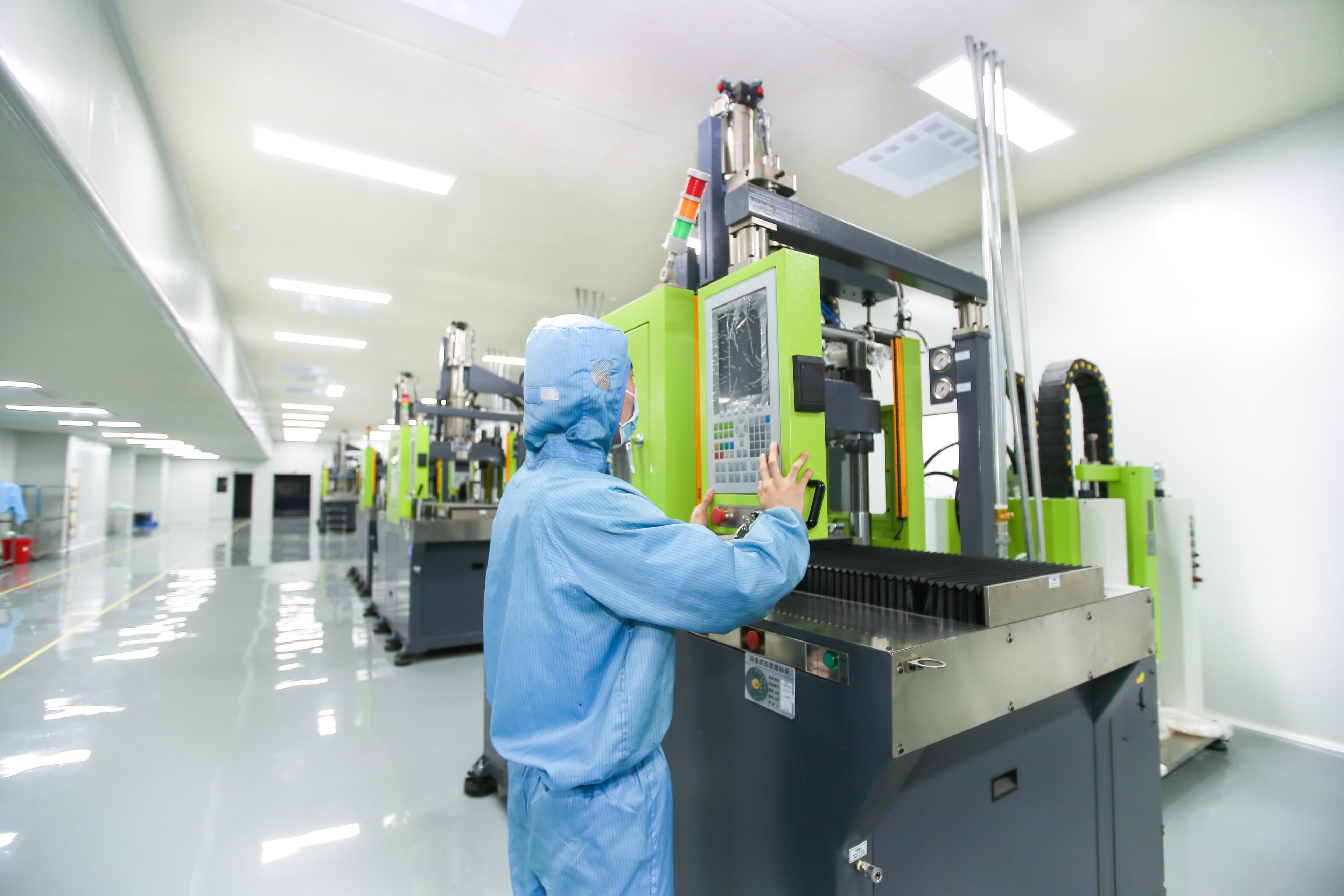 Operator working with production equipment in a clean manufacturing area