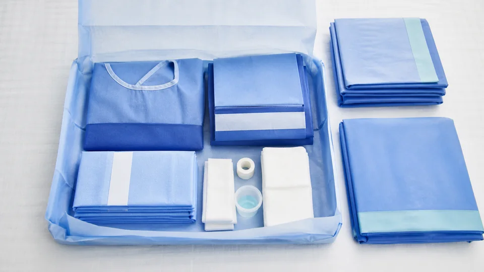 Custom surgical pack with gown, drapes and procedure components arranged together